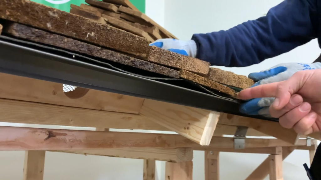 Photo of roofer picking the right cedar shake shingles to cover the gaps on lower levels of installed shingles the roof.