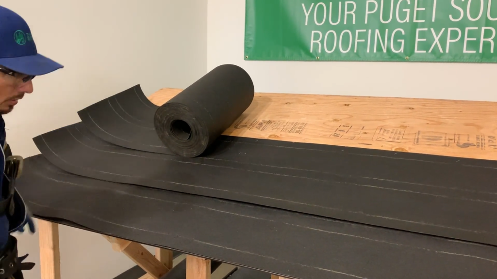 Photo of roofer installing underlayment on a demo roof for a cedar shake shingle roof.