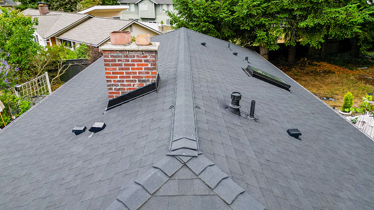 Closeup view of the New Composite Asphalt Shingle Roof home in Renton, Washington, with roof flashing and skylight.