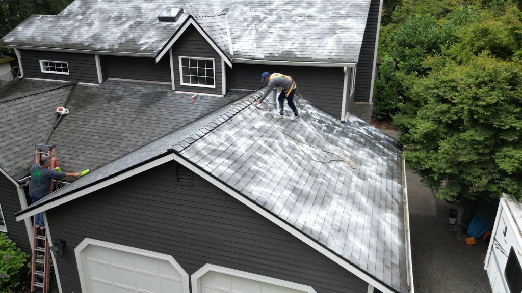 Three Tree Roofing Roofer maintaining and cleaning a roof in Seattle, Washington area.