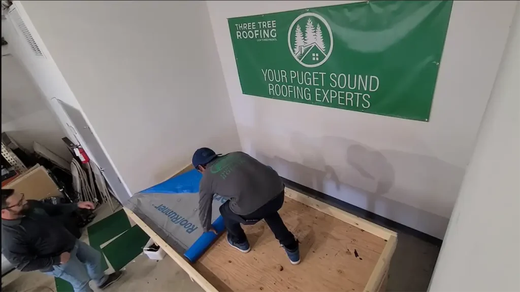 Three Tree Roofing Roofer demonstrating the installation of a synthetic-fabric underlayment to act as a paper barrier for the fanfold and material.